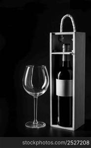 empty glass near box with wine bottle