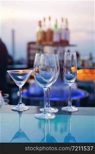 Empty glass of cocktail and champagne on counter bar of bartender in luxury rooftop
