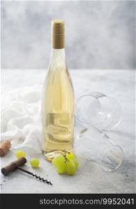 Empty glasses and bottle of summer white wine with grapes, corks and corkscrew on light table background.