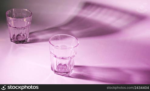 empty glasses with dark shadow pink background