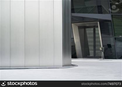Empty ground in front of modern steel wall buildings .