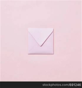Empty handmade envelope for congratulation card on a light pink background with copy space. Mockup.. Handcraft envelope mockup for post card on a pastel pink background.