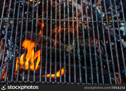 Empty hot charcoal barbecue grill with bright flame. Hot burning grill, outdoors cooking food