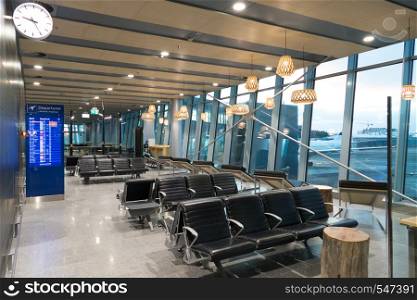 empty interior of the Vanta airport hall with a clock, arrival and departure board, with seats and panoramic windows. Helsinki. Helsinki, Finland - January 15, 2018: empty interior of the Vanta airport hall with a clock, arrival and departure board, with seats and panoramic windows. Helsinki