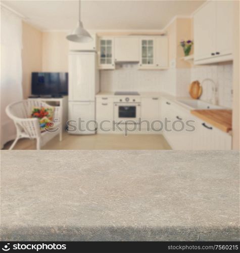 Empty kitchen stone table top with white modern kitchen in background. Kitchen table top