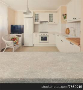 Empty kitchen stone table top with white modern kitchen in background. Kitchen table top