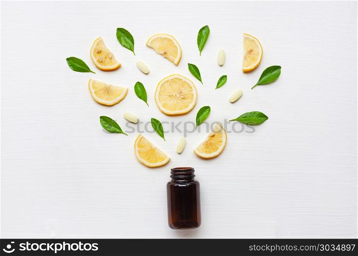 Empty medicine bottle with fresh lemon, leaves and vitamin C.. Empty medicine bottle with fresh lemon, leaves and vitamin C. on white background.