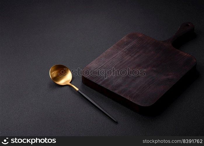 Empty metal spoon on dark textured concrete background. Cutlery, preparation for dinner