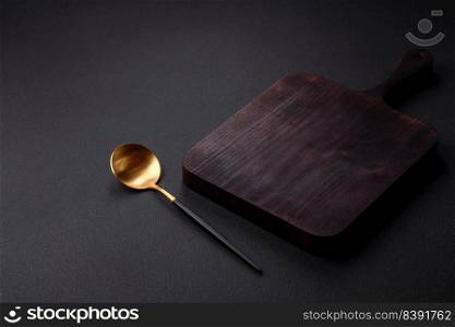 Empty metal spoon on dark textured concrete background. Cutlery, preparation for dinner