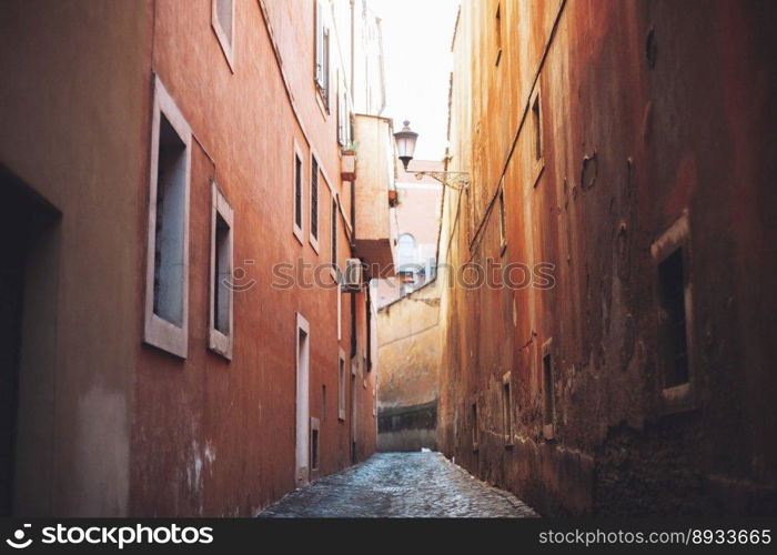 empty narrow city street made of cobblestones between old houses