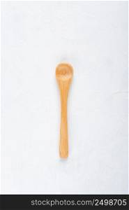 Empty new clean small bamboo wooden spoon on white table background top view flat lay.