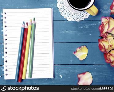 Empty notebook and colorful wooden pencils, top view