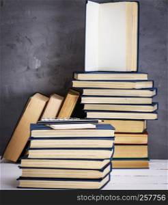 empty notebook with white sheets and a black pencil are on a stack of books
