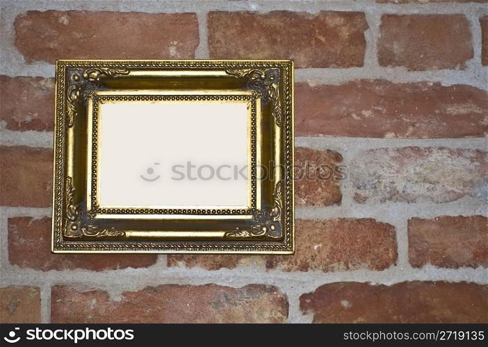 empty old golden frame on a red brick wall