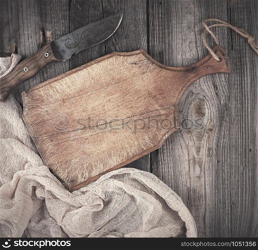 empty old wooden kitchen cutting board and knife on a table, view from the top