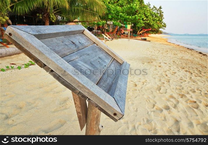 Empty old wooden Whiteboard (menu board) on a tropical beach