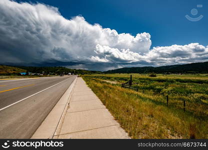 Empty open highway and stormy clouds in Wyoming. Empty open highway and stormy clouds in Wyoming, USA