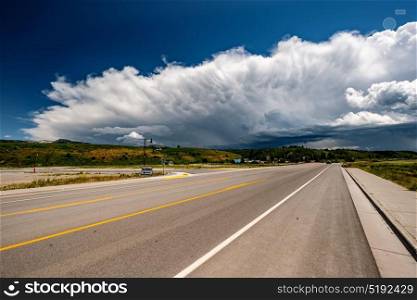 Empty open highway and stormy clouds in Wyoming, USA