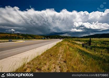 Empty open highway and stormy clouds in Wyoming, USA