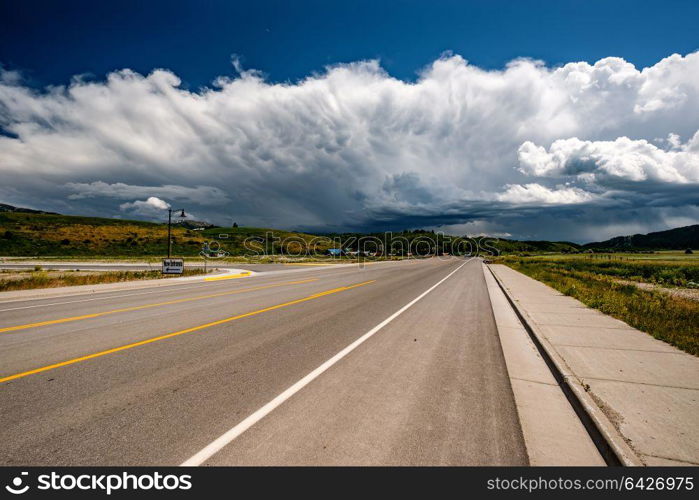 Empty open highway and stormy clouds in Wyoming, USA