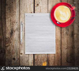 empty paper and pen with red cup coffee on wood table background
