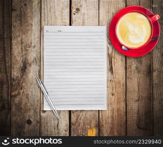 Empty paper and pen with red cup coffee on wood table background