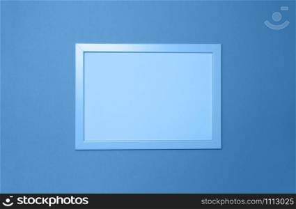 Empty photoframe on background in Classic Blue colour. Copy space for text. Horizontal. Color of the year 2020 concept, harvesting for mock up. Top view. Minimal style concept.