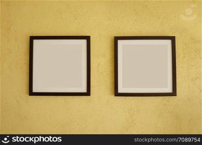 Empty picture frames on vintage yellow walls and have copy space for design in your work concept.