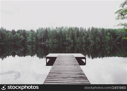 Empty pier of a beautiful lake, toned, atmospheric photo. The concept of the beauty of nature, peace, loneliness