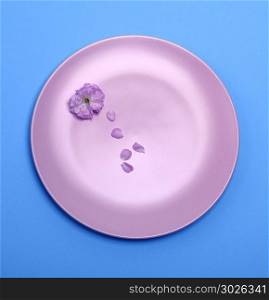 empty pink ceramic dish on a blue background, top view. empty pink ceramic dish