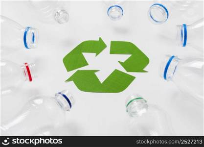 empty plastic bottles around recycling logo