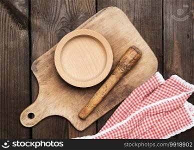 empty plate and old brown rectangular wooden kitchen cutting board on the table, top view