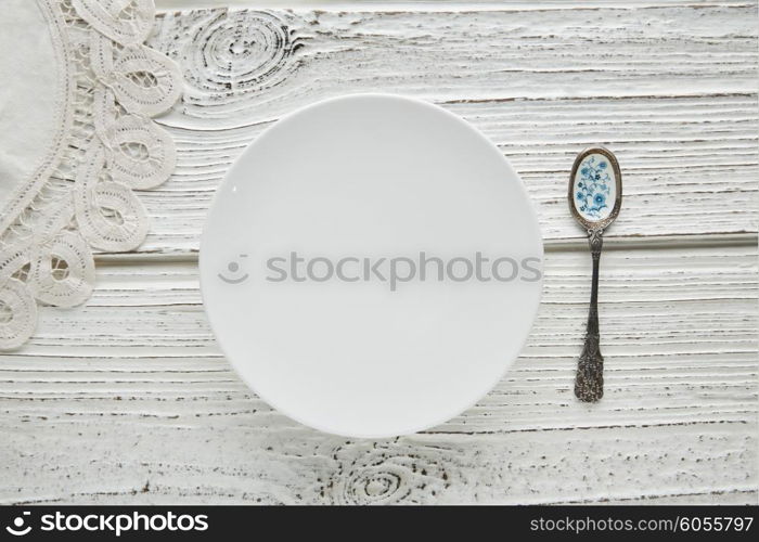 Empty plate dish with spoon food hungry concept monochromatic white wood background