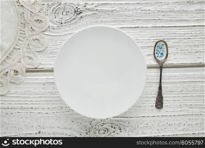 Empty plate dish with spoon food hungry concept monochromatic white wood background