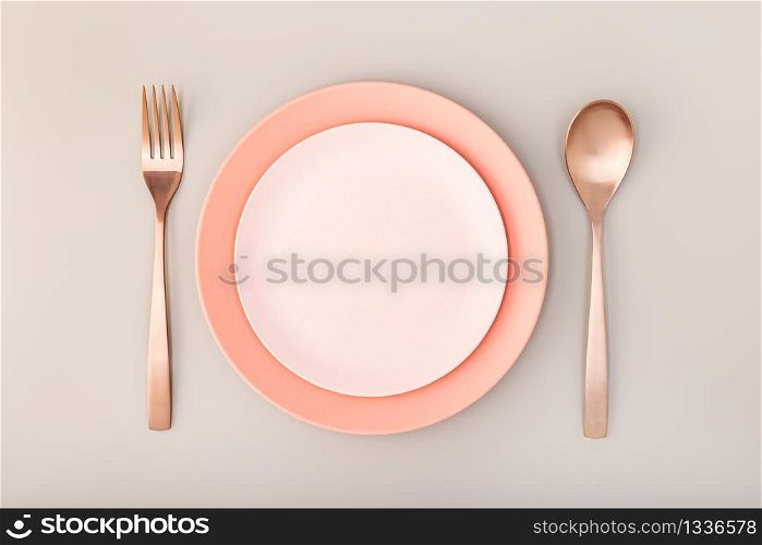 Empty Plate, fork and knife on Table. Pink Pastel tones. Mock up