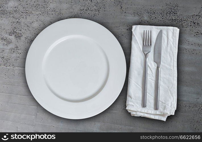 Empty plate with cutlery on concrete background.. Empty plate with cutlery on concrete background