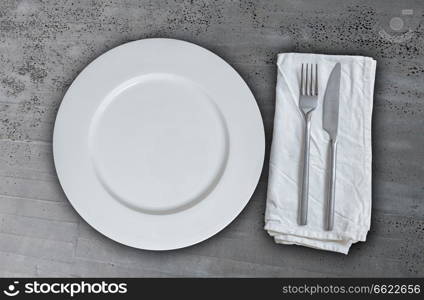 Empty plate with cutlery on concrete background.. Empty plate with cutlery on concrete background