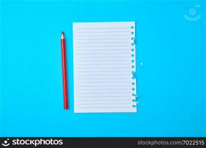 empty rectangular white sheet torn out of notepad and wooden red pencil on a blue background