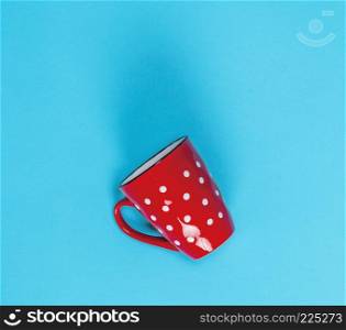 empty red ceramic mug in a white circle on a blue background, top view