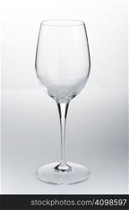 Empty red wine glass on the white reflective table