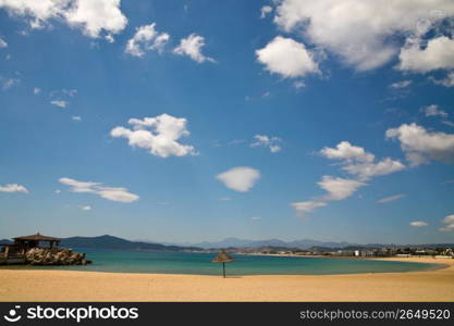 Empty remote tropical beach with ocean in background and blue sky