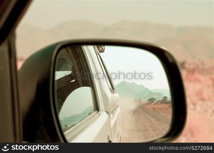 empty road in the african desert - view in the car mirror