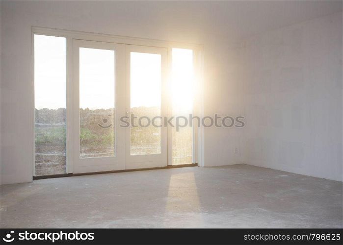 Empty room with big window , frame and double doorsnew construction, still in progress with sunlight shining, building concept. Empty room with big window , frame and double doorsnew construction, still in progress with sunlight shining