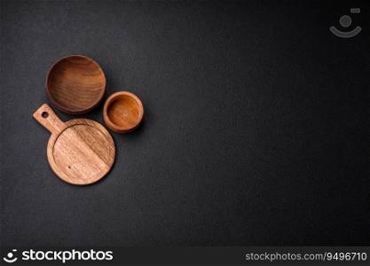 Empty round kitchen wooden cutting board in brown color on a dark textured concrete background