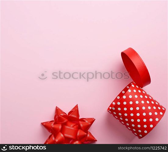 empty round red cardboard box in white polka dots on a pink background, holiday backdrop