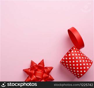empty round red cardboard box in white polka dots on a pink background, holiday backdrop
