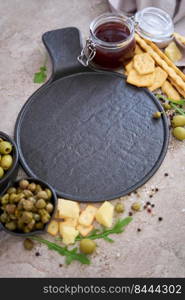 Empty round serving board with olives, capers and on kitchen table.. Empty round serving board with olives, capers and on kitchen table