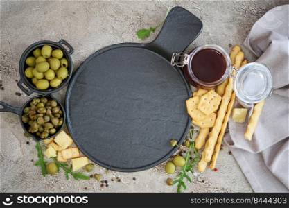 Empty round serving board with olives, capers and on kitchen table.. Empty round serving board with olives, capers and on kitchen table