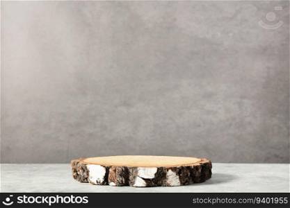 Empty round wooden podium for product presentation on natural concrete background. Natural materials background for cosmetic advertising with cylinder shape showcase. Mockup concept.