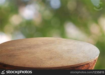 Empty rounded wooden table in front of abstract blurred green bokeh light of garden and nature light background. For montage product display or design key visual layout - Image